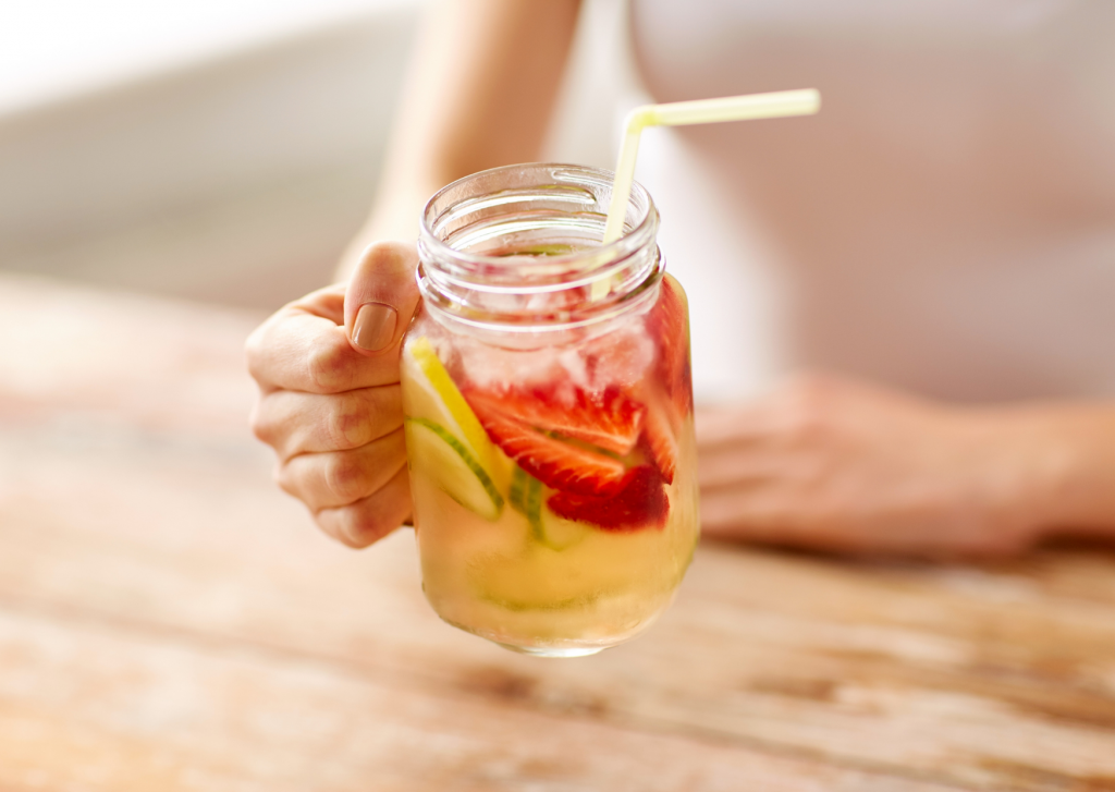 boisson fraiche avec des fruits et des rondelles de légumes dans un mug avec une paille 